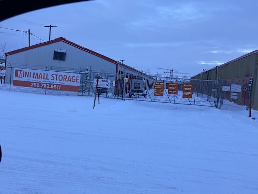 a building with a fence and signs in the snow
